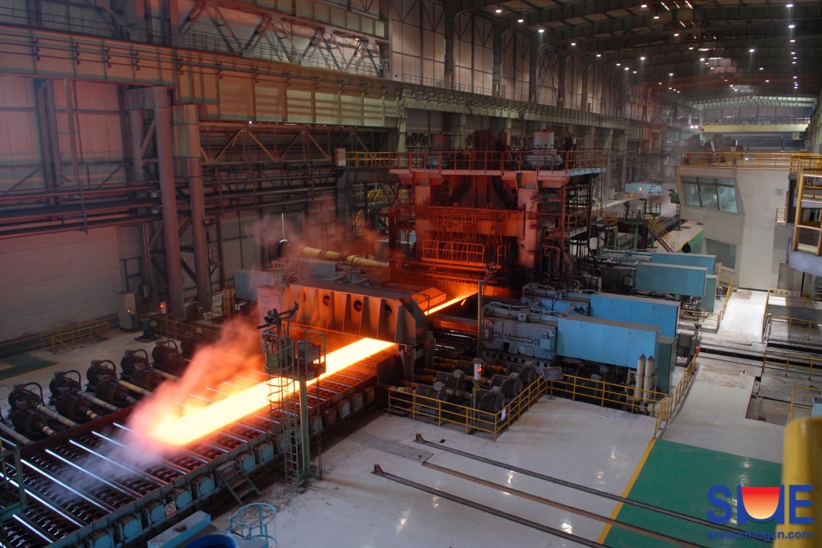 Heated steel slab running through the rolling mill