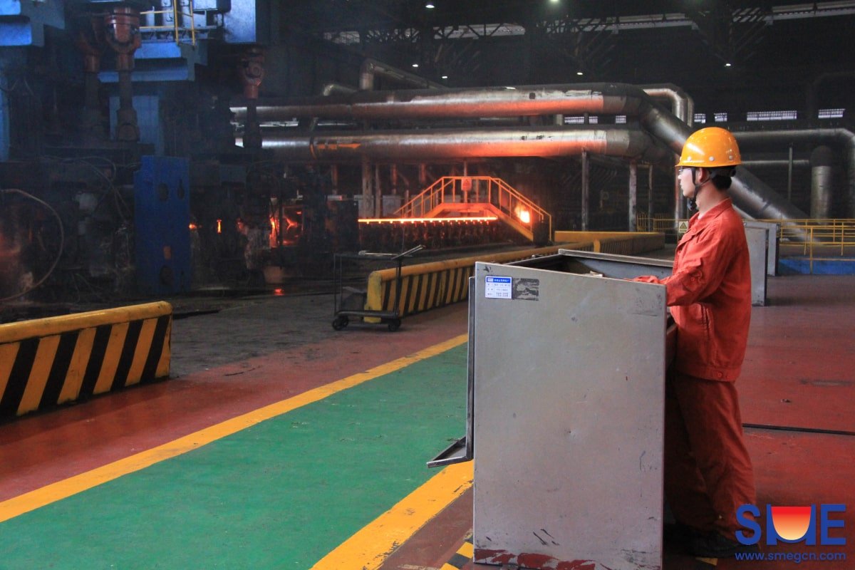 A worker is monitoring and controlling the rolling process