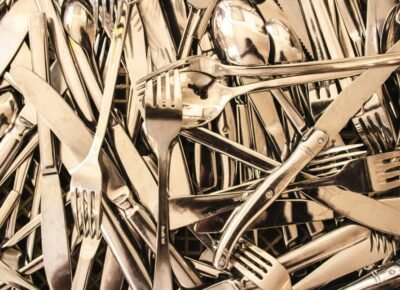 A lot of stainless steel forks and knives