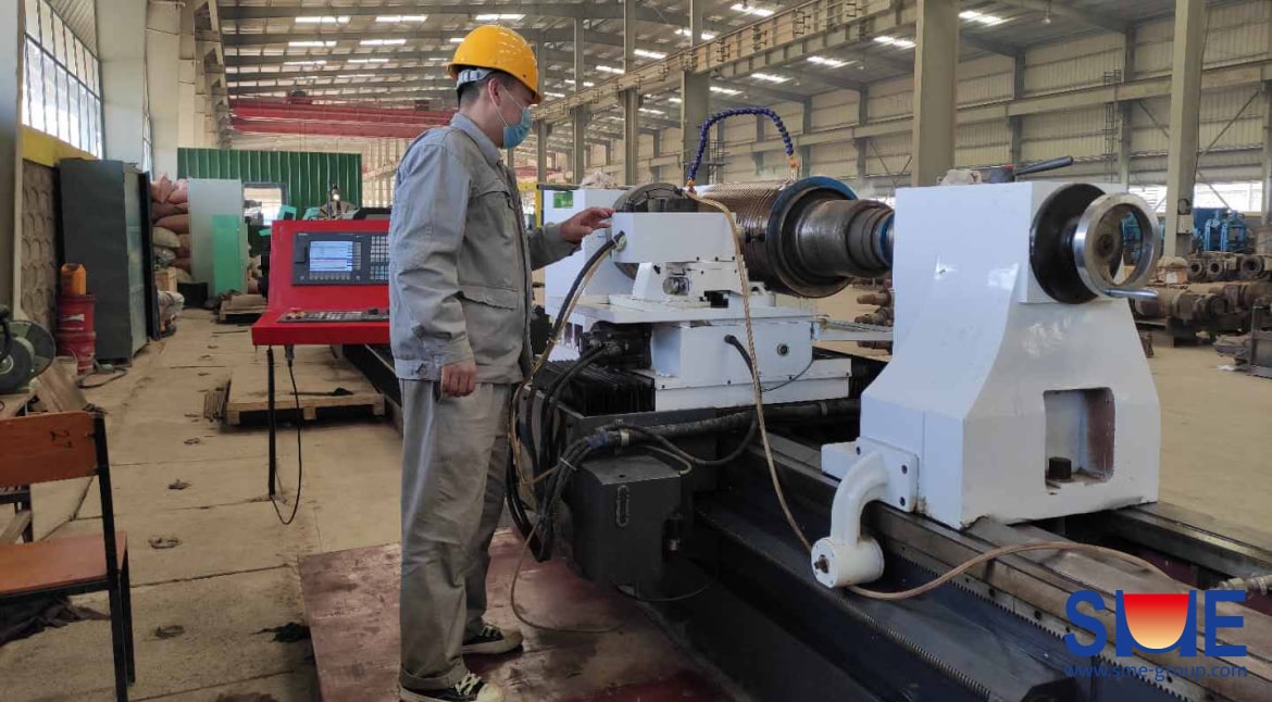 An SME worker is operating the metal working equipment